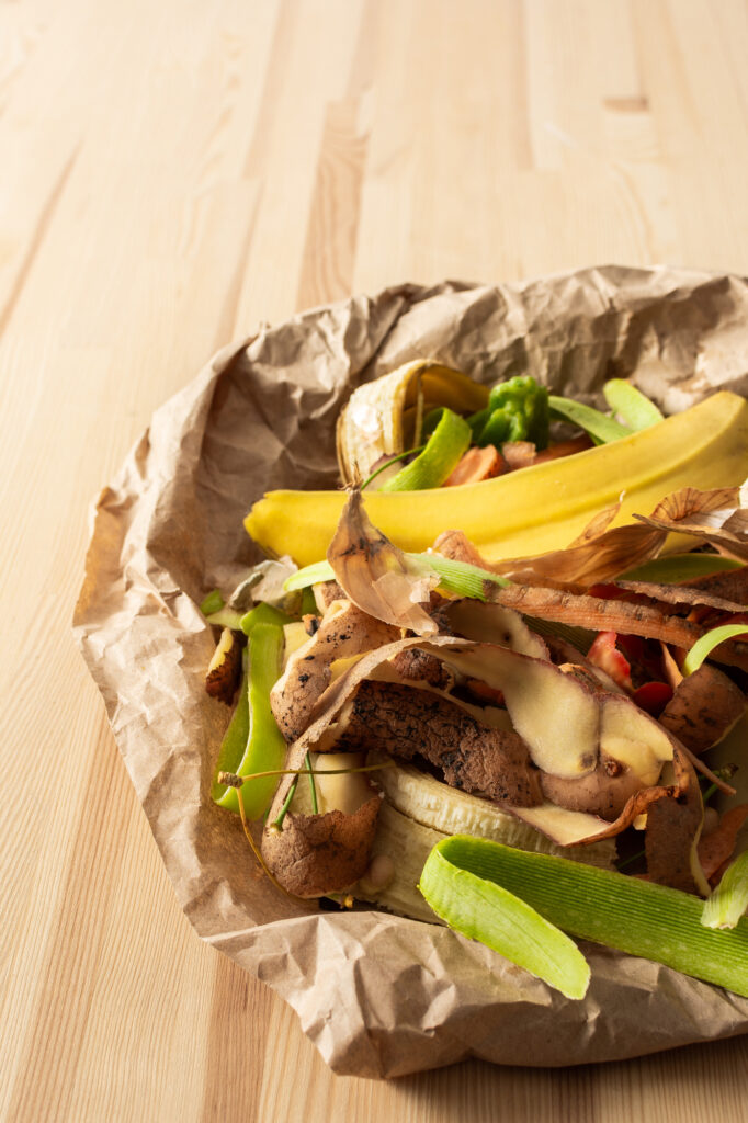 Food organic waste on eco friendly parchment paper, fruit and vegetable peel, garbage sorting and recycling